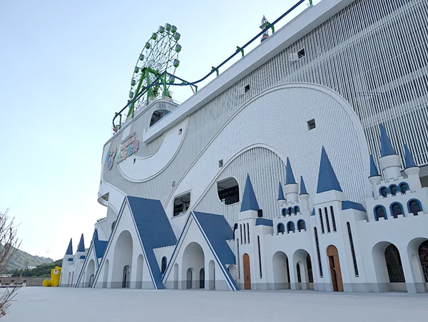 A huge white castle-trimmed building with a Ferris wheel on the roof