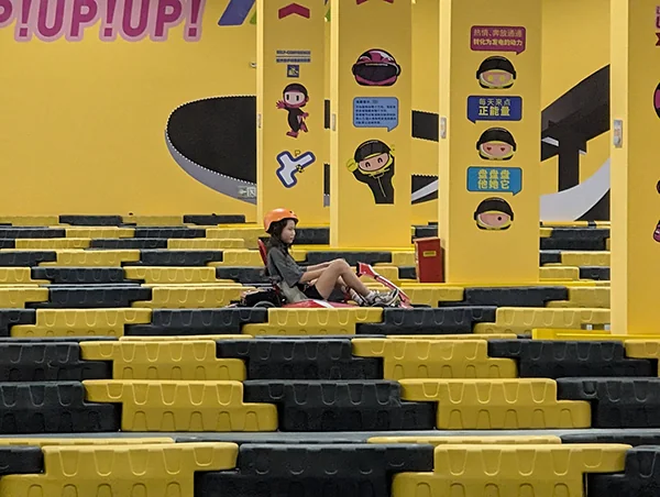 Niuniu in a helmet sitting alone on an empty ninja-themed course