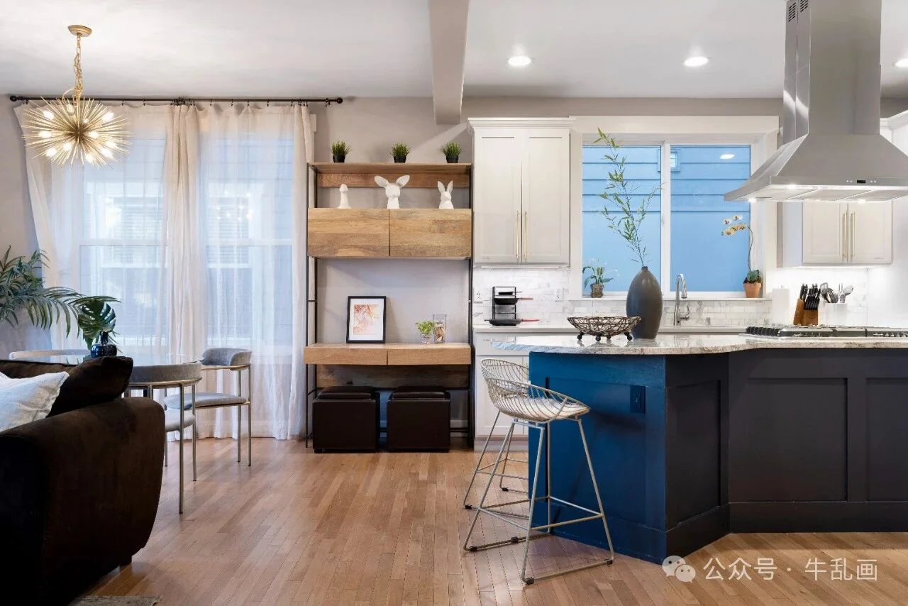Staged kitchen and dining area with a navy island and wood floors