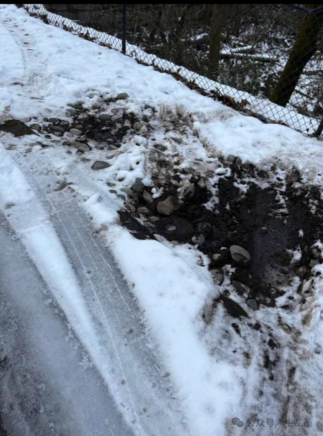 Two muddy tire craters gouged into the snowy flower bed by the driveway