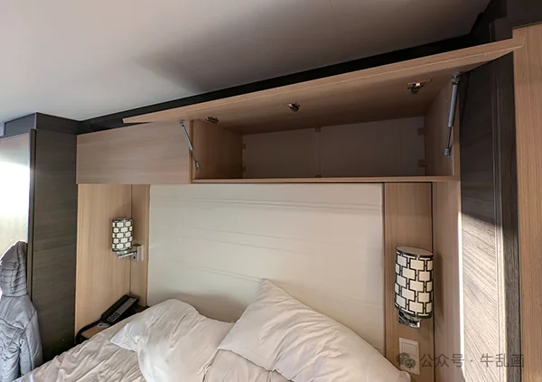 Overhead storage cabinets above the bed in the cabin