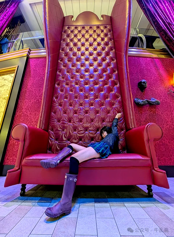 Niuniu sprawled dramatically in a giant red throne-sofa