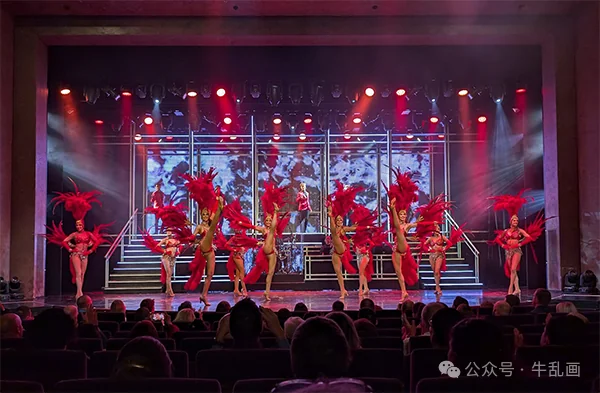 Showgirls in red feathers filling the theater stage