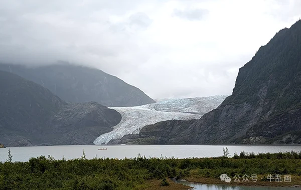 Mendenhall Glacier flowing down between dark mountains